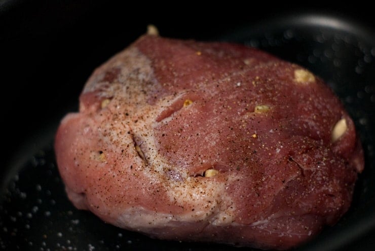 Seasoned Pork Meat with garlic on a black skillet.