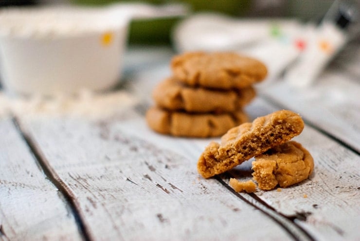 Five simple Peanut Butter Cookies on a wooden table.