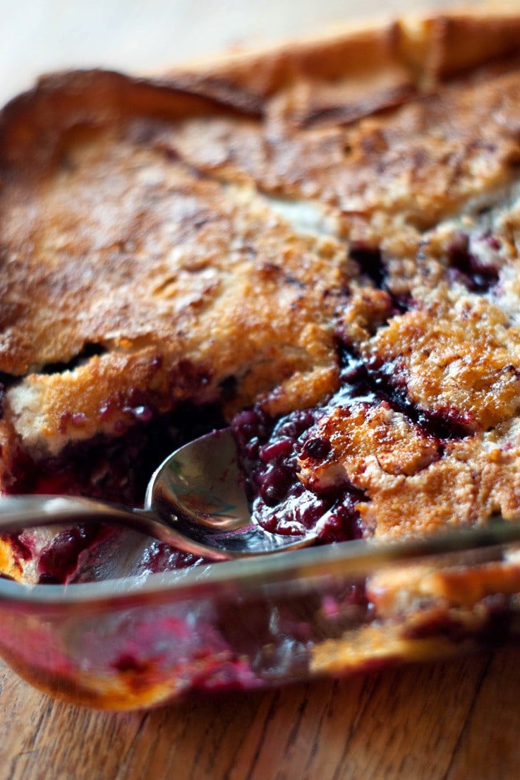 Scooping out simple Boysenberry Cobbler with a silver spoon.