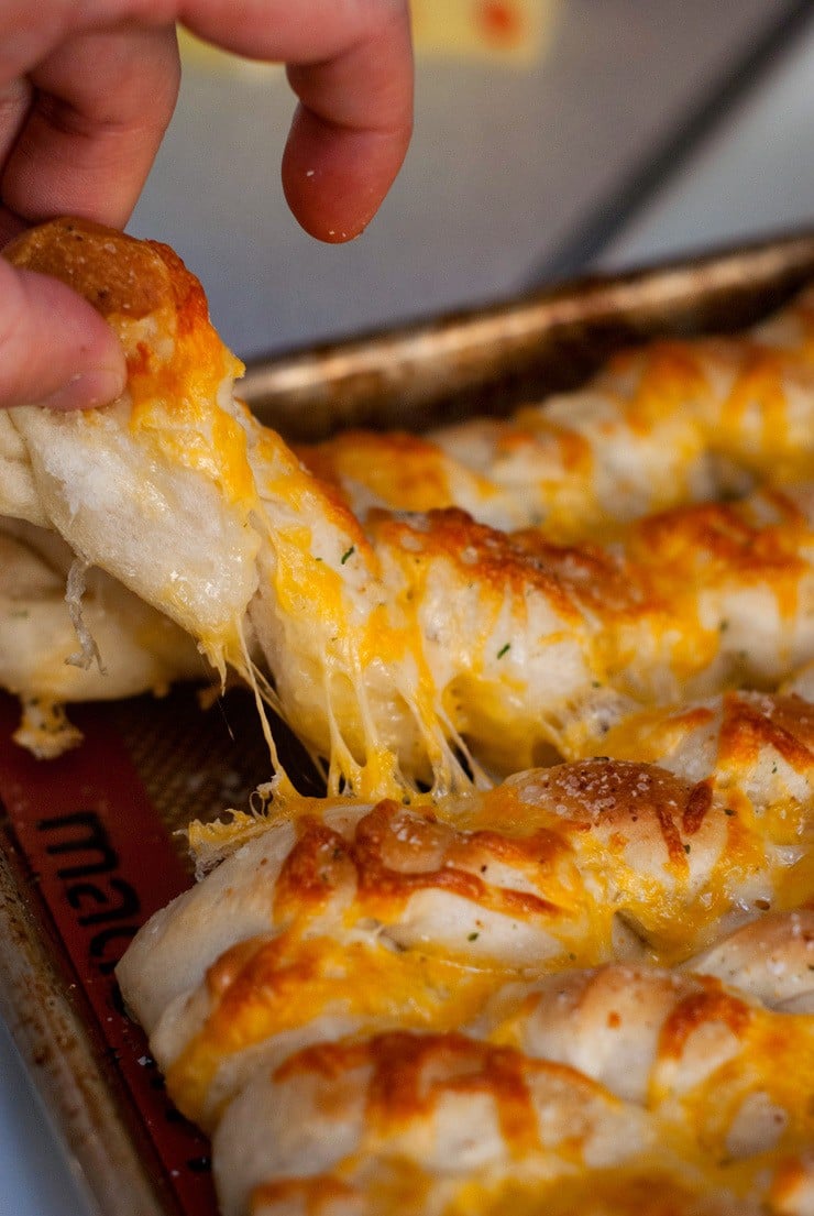 Pulling cheesy Breadsticks apart.