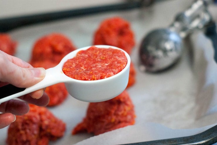 Burger meat in a white measuring spoon.