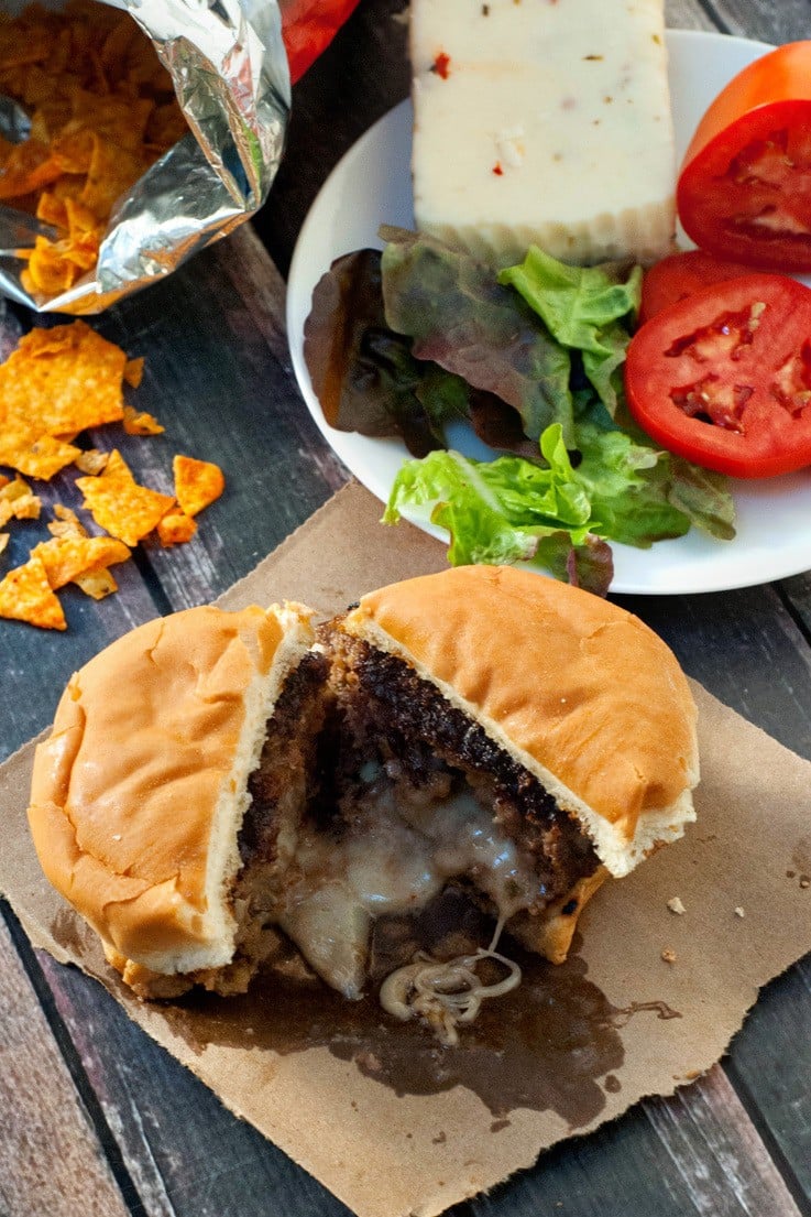 Delicious Pepper Jack Stuffed Doritos Burger split in half.