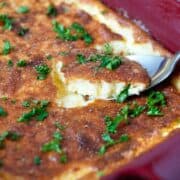 Cheddar Garlic spoon bread in a red casserole dish
