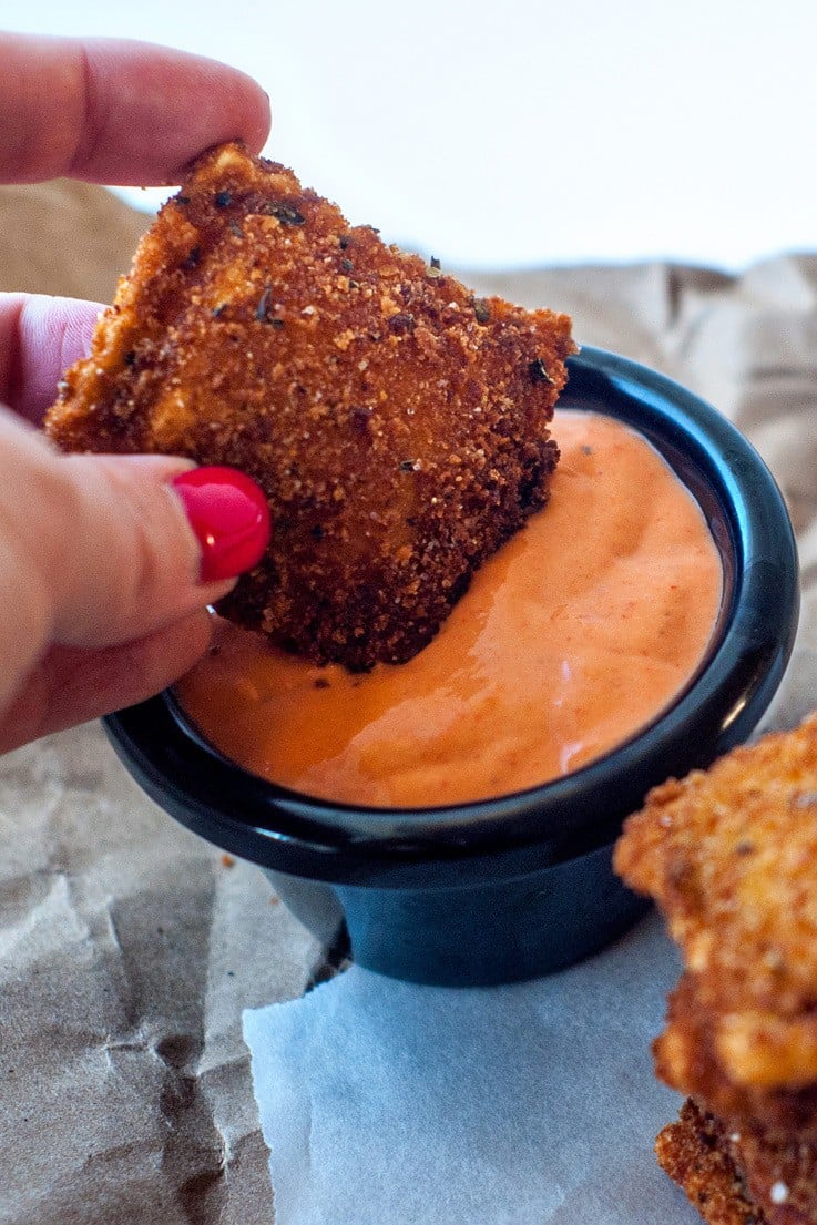 Dipping a delicious Crispy Ravioli into an easy Roasted Red Pepper Sauce.