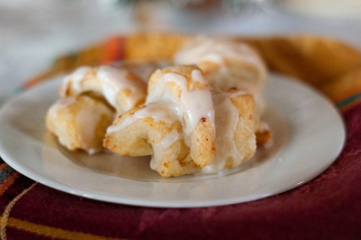 Easy Cottage Cheese Butterhorns recipe drizzled with glaze on a white serving plate.