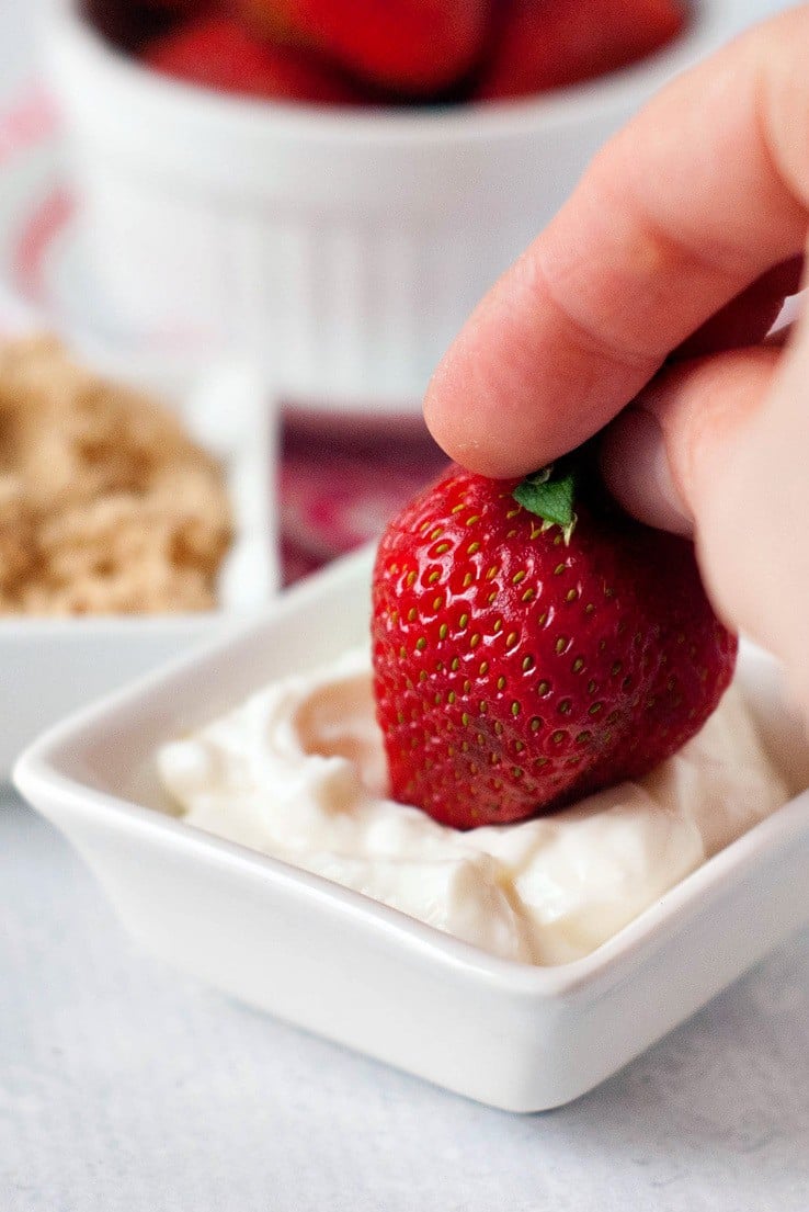 Strawberry being dipped in sour cream