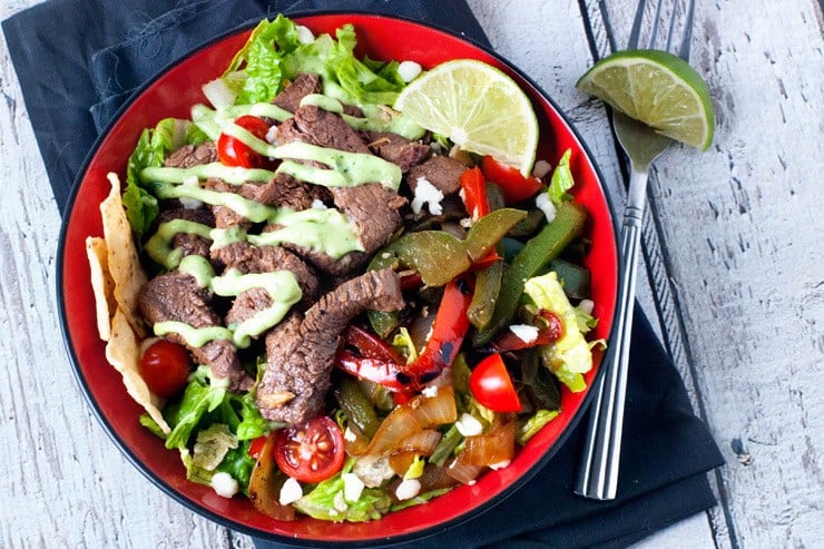 Skillet Steak Fajita Salads in red bowl with fork and lime
