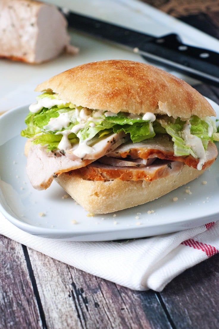 Pork tenderloin on a ciabatta roll with lettuce and caesar dressing
