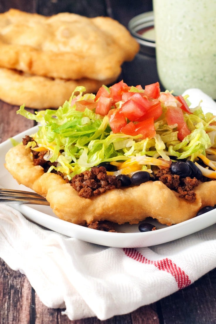 Navajo Tacos on a white plate with toppings