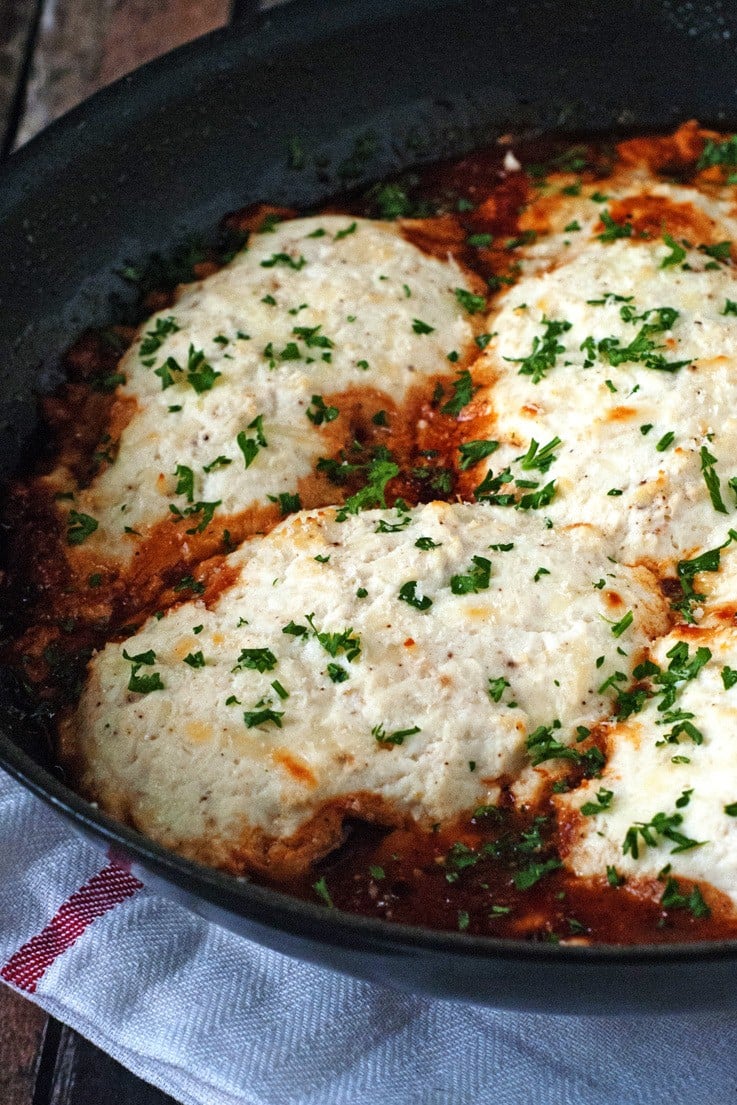 Baked chicken topped with ricotta cheese and parsley