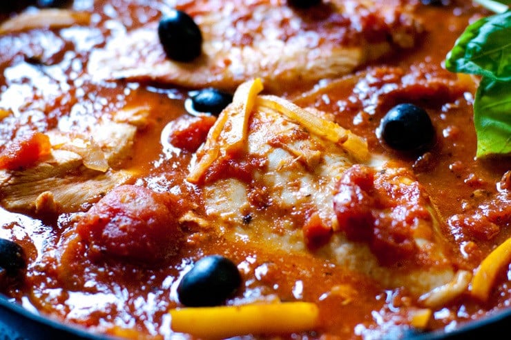 Close up of easy chicken cacciatore in a tomato sauce with peppers, olives, and onions.