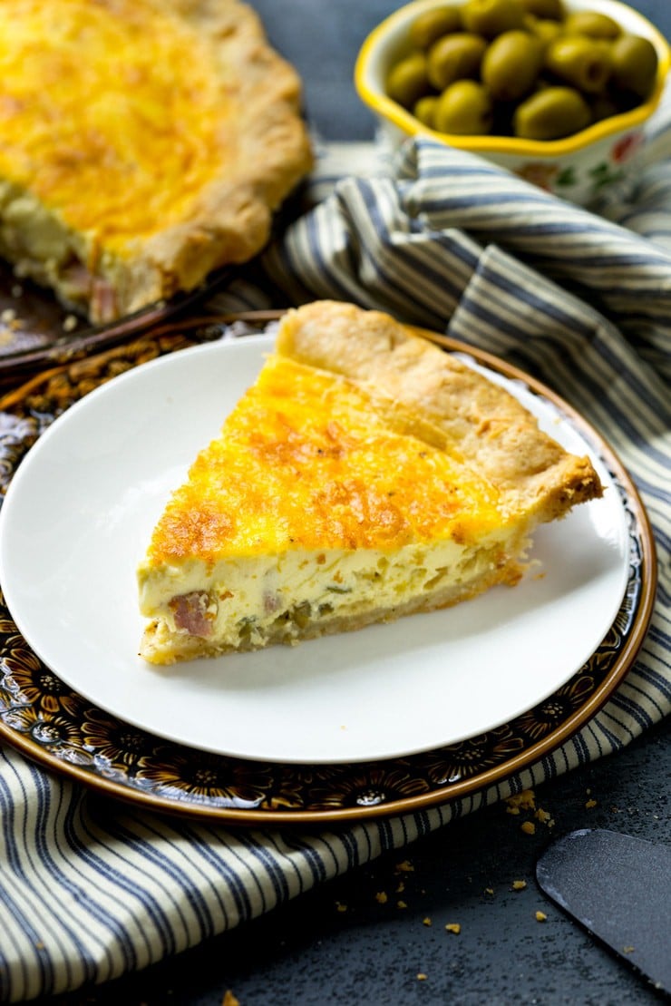 A piece of the best basic quiche recipe on a white plate