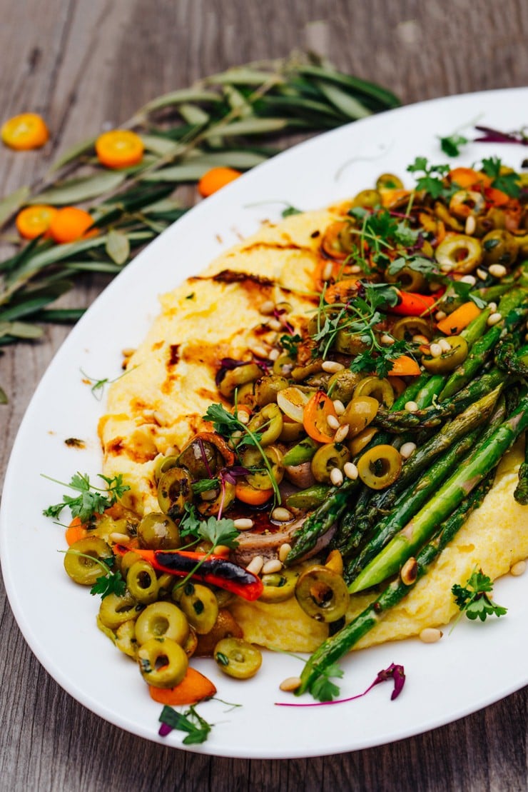 Polenta topped with olives and asparagus