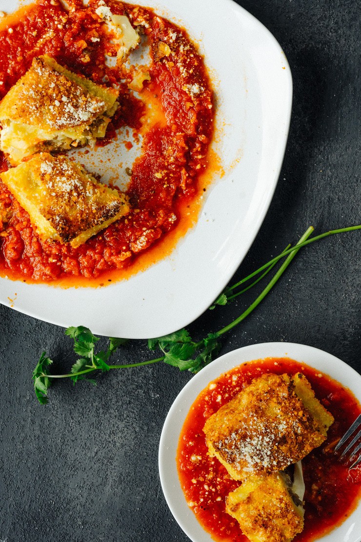 Lasagna bomb on tomato sauce on white plate