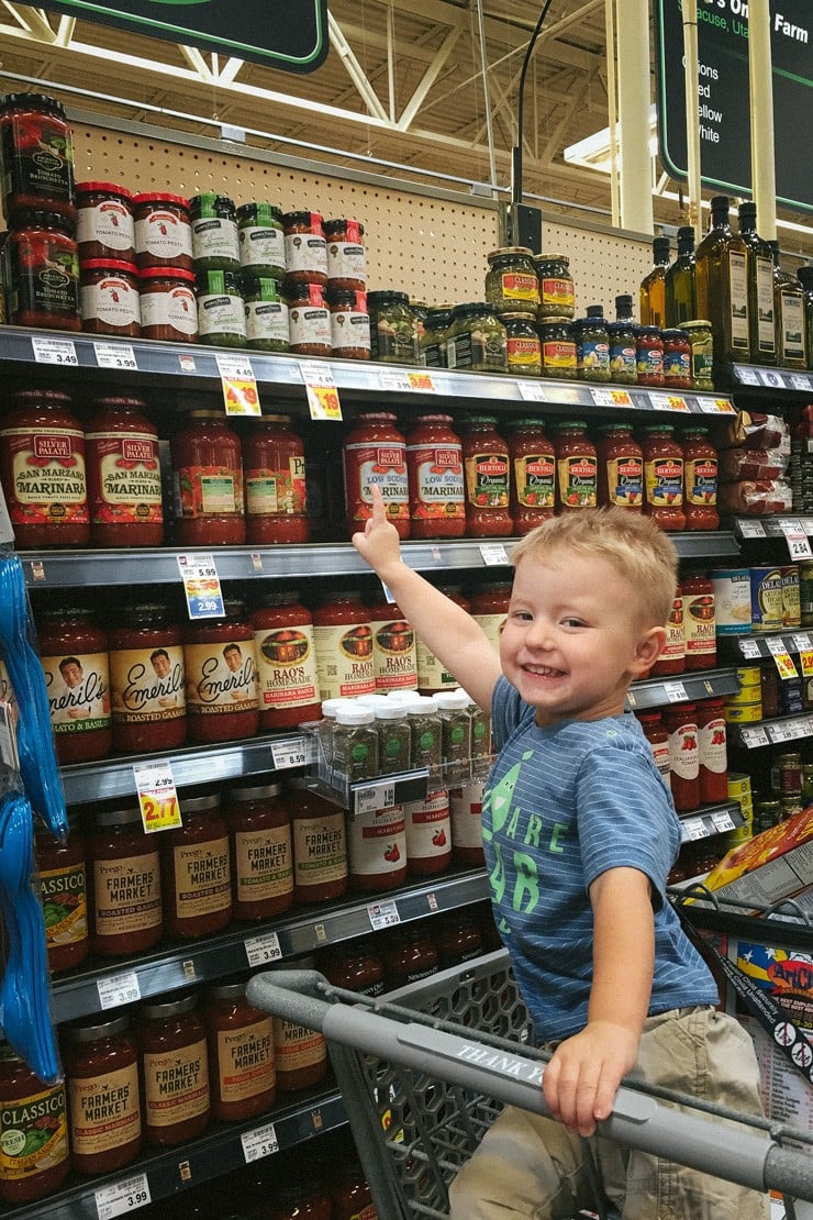 Bacon envolto pesto de frango-menino no corredor de supermercado