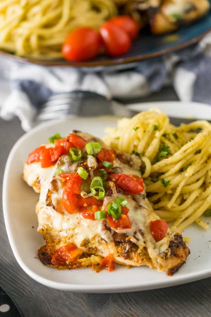 baked Smothered chicken on a white plate with pasta