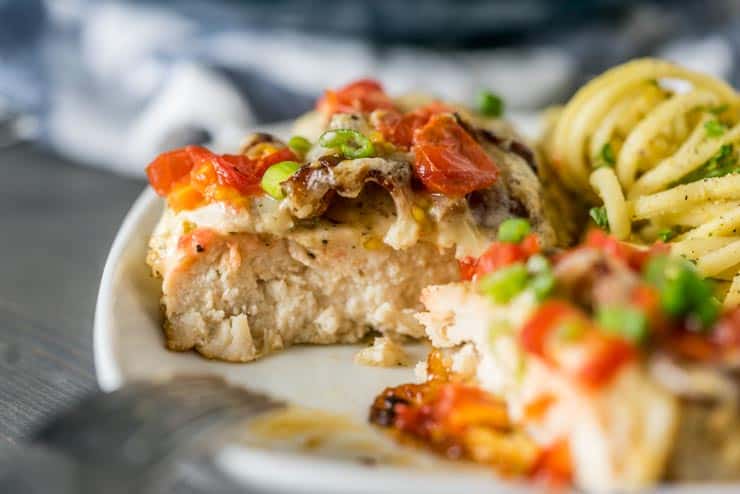 Smothered Chicken Breast cut in half on white plate