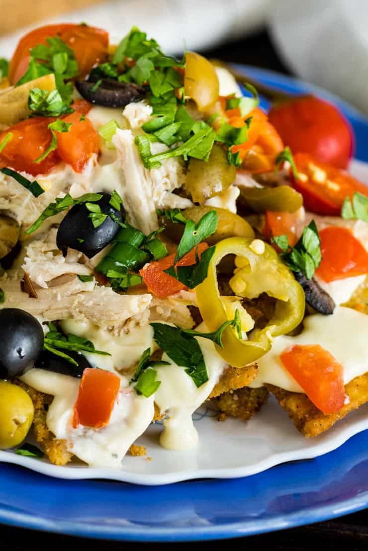 Italian Nachos with olives, cherry peppers, chicken and a homemade alfredo sauce.