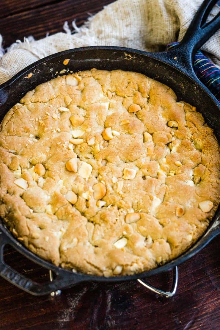White Chocolate Macadamia Nut Pizookie baked in a skillet and on a tabletop