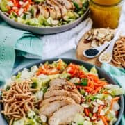 Chinese Chicken Salad in 2 grey bowls on a white table cloth and turquoise napkins