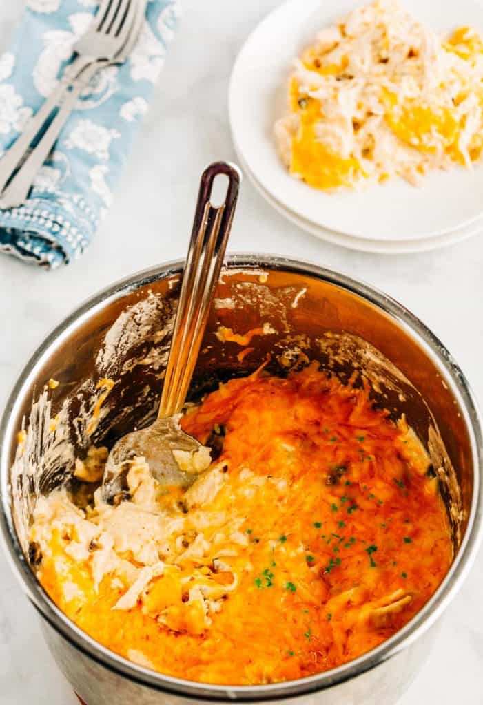 Pot and spoon with enchilada casserole inside