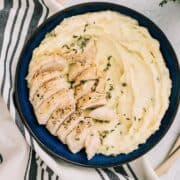 Blue plate with mashed potatoes and sliced chicken