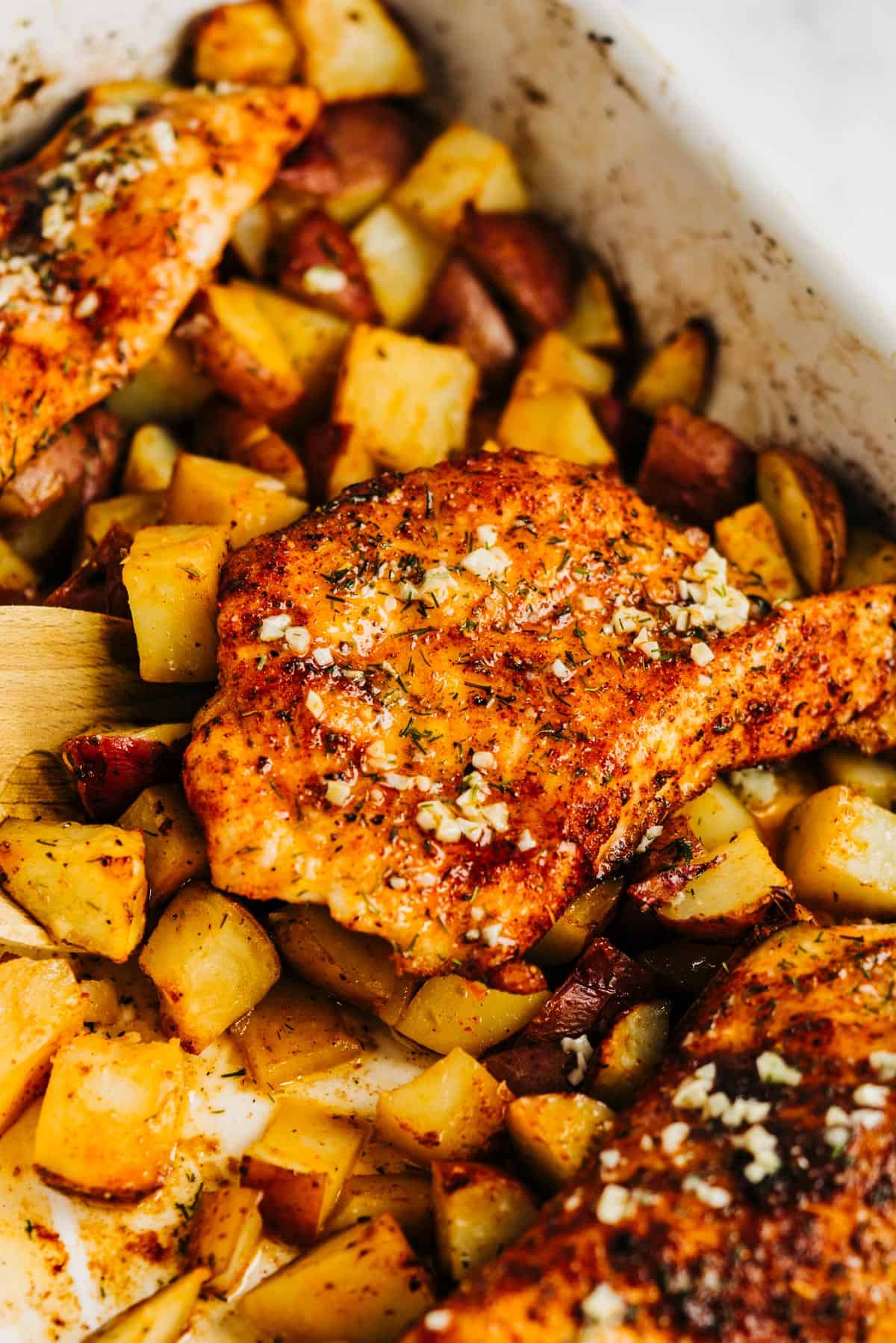 Garlic chicken and potatoes in a white dish